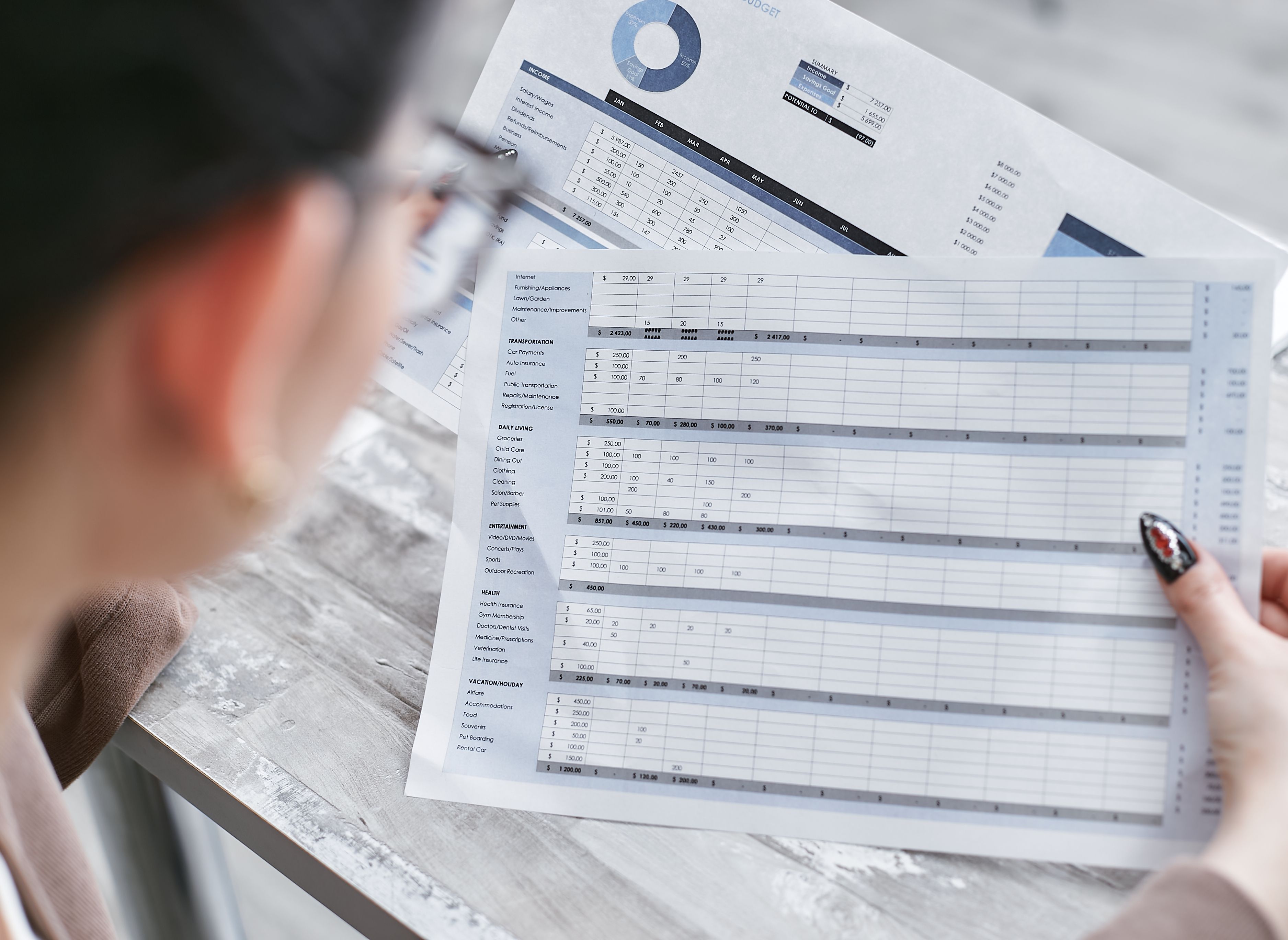 person studying printed out spreadsheets and charts